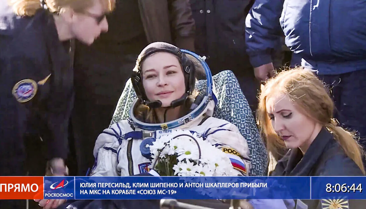 In this photo taken from video footage released by Roscosmos Space Agency, actress Yulia Peresild sits in a chair shortly after the landing of the Russian Soyuz MS-18 space capsule, southeast of the Kazakh town of Zhezkazgan, Kazakhstan, on Oct. 17, 2021. (Roscosmos Space Agency via AP)