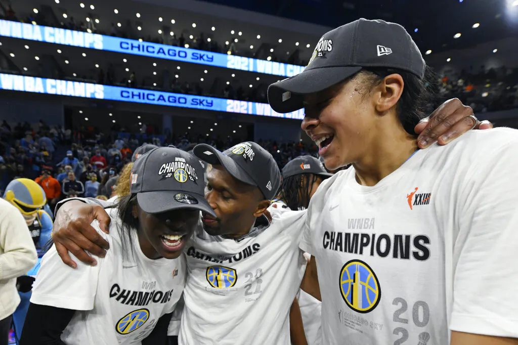 Chicago Sky head coach James Wade, center, celebrates with Candice Parker, right, and Kahleah Copper, left, after defeating the Phoenix Mercury in Game 4 of the WNBA Finals to become champions in Chicago on Oct. 17, 2021. (Paul Beaty/AP Photo)