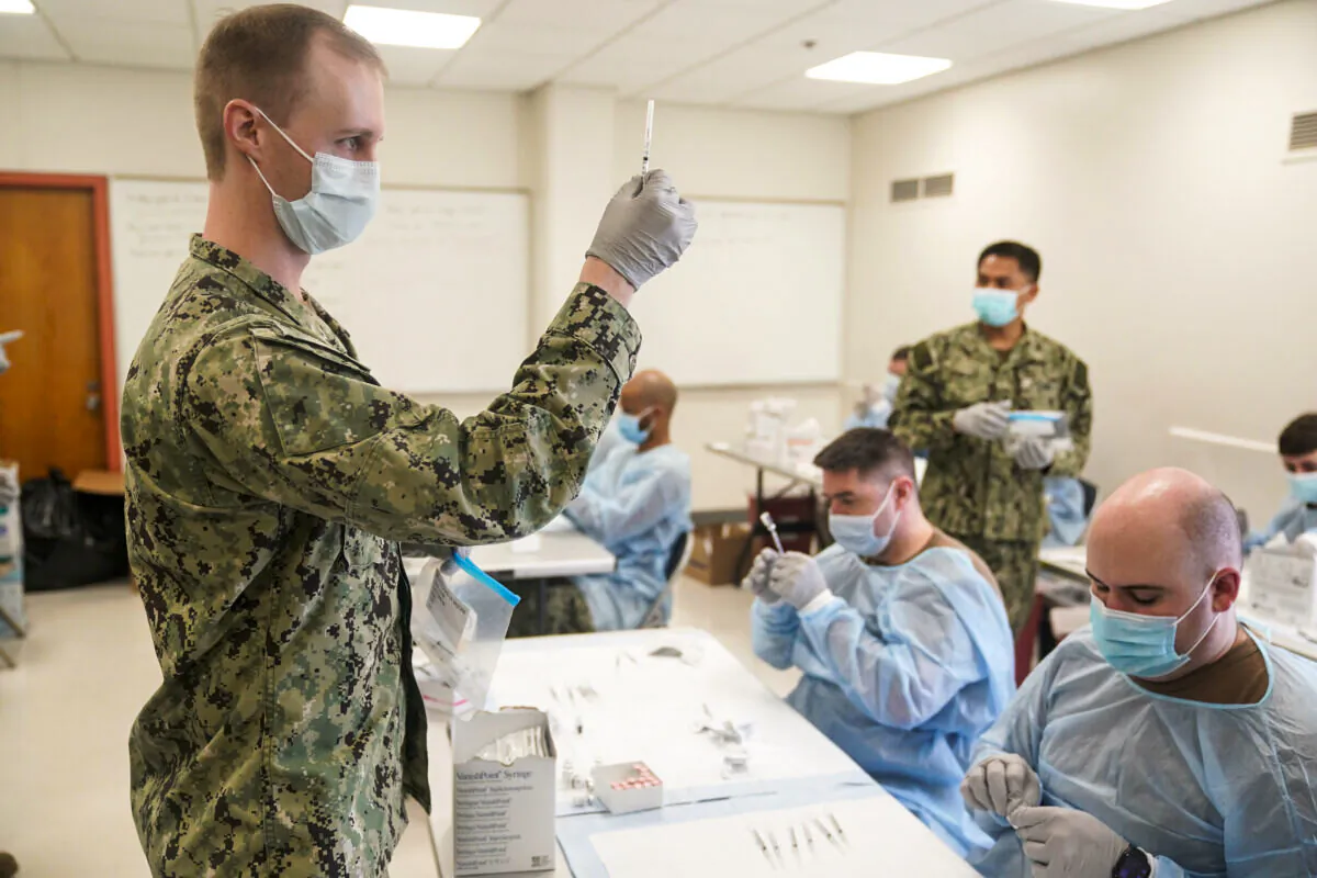 Navy personnel prepare doses of a COVID-19 vaccine at a vaccination site in New York City on Feb. 24, 2021. (Seth Wenig/Pool/AFP via Getty Images)