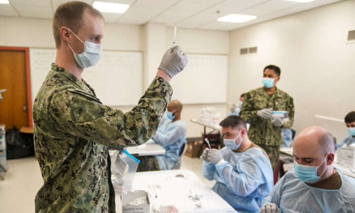 Navy personnel prepare doses of a COVID-19 vaccine at a vaccination site in New York City on Feb. 24, 2021. (Seth Wenig/Pool/AFP via Getty Images)