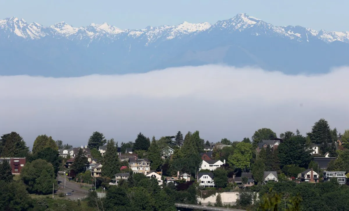 Residential homes are visible under the backdrop of the Olympic Mountains and low fog in the Magnolia neighborhood of Seattle, Wash., on May 14, 2021. (Karen Ducey/Reuters)