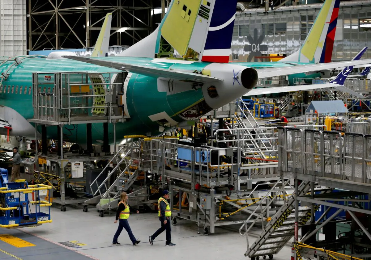 Employees walk by the end of a 737 Max aircraft at the Boeing factory in Renton, Wash., on March 27, 2019. (Lindsey Wasson/Reuters)