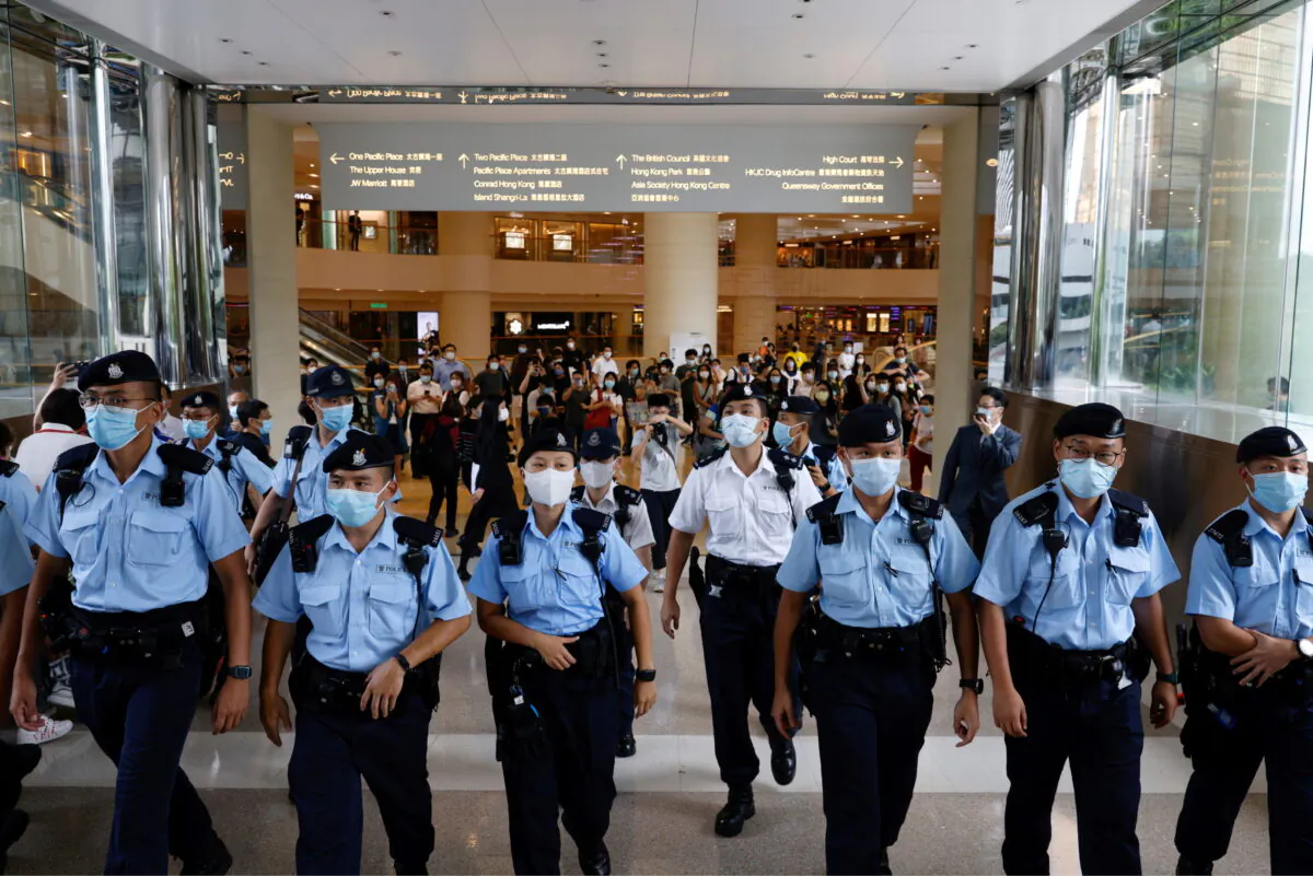 Police tell supporters to leave during the court hearing of Tong Ying-kit, the first person charged under a new national security law near the High Court, in Hong Kong, on July 30, 2021. (Tyrone Siu/Reuters)