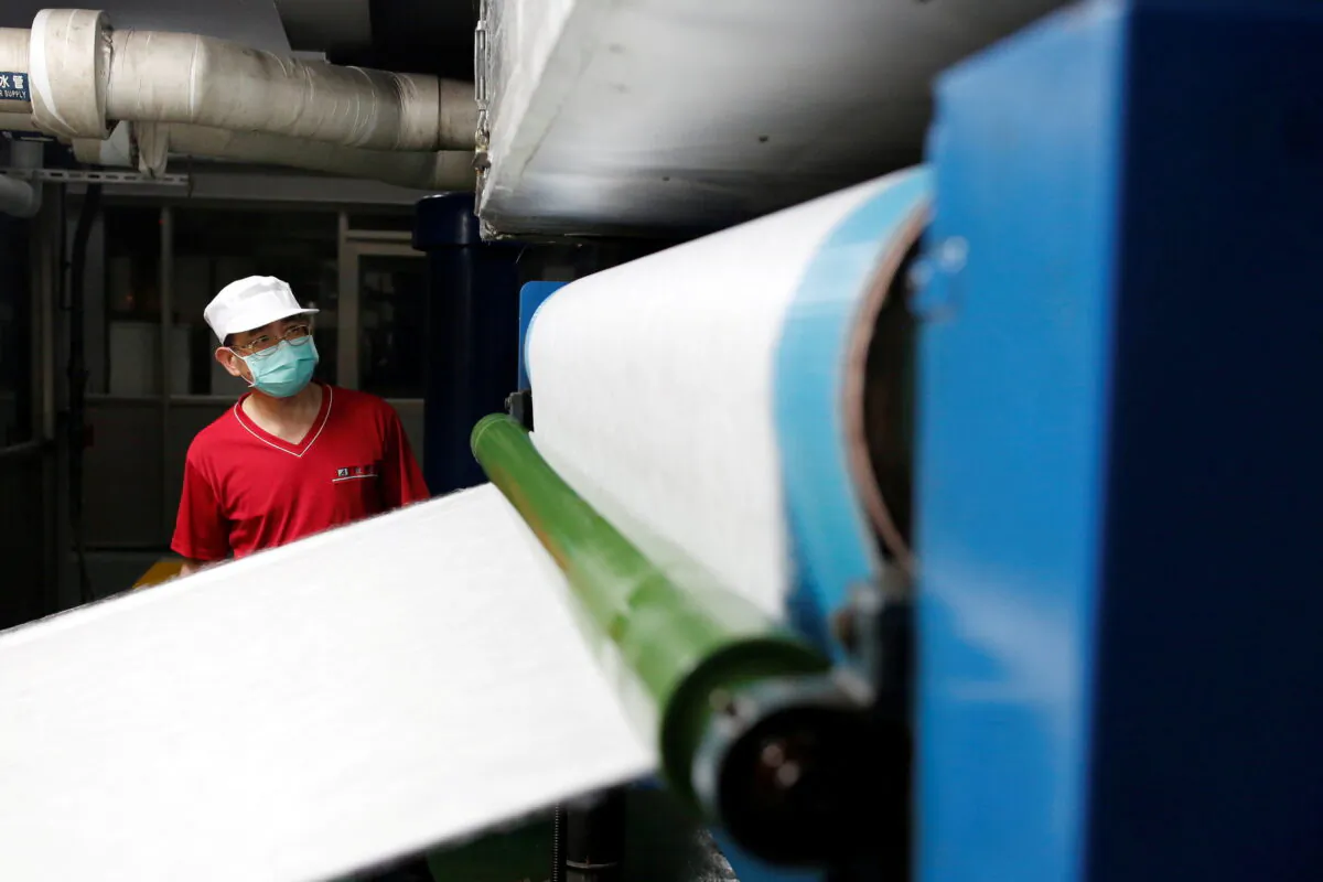 A staff member works inside a non woven filter fabric factory, where the fabric is used to make surgical face masks, in Taoyuan, Taiwan, on March 30, 2020. (Ann Wang/Reuters)