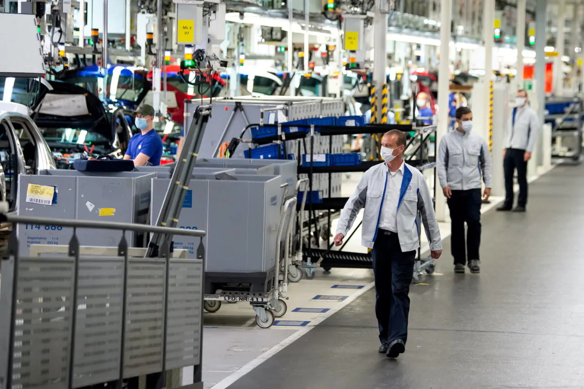 Staff wear protective masks at the Volkswagen assembly line in Wolfsburg, Germany, on April 27, 2020. (Swen Pfoertner/Pool via Reuters)