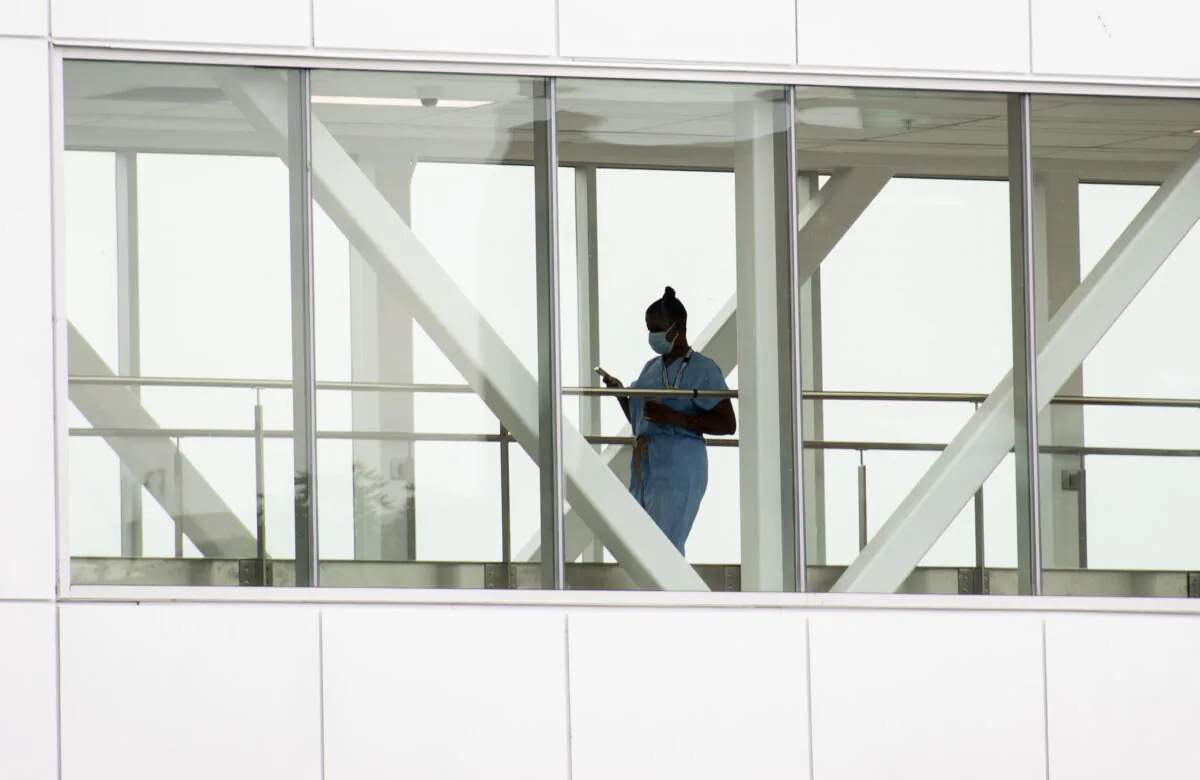 A health-care worker crosses a walkway at a hospital in Montreal in a file photo. (The Canadian Press/Graham Hughes)