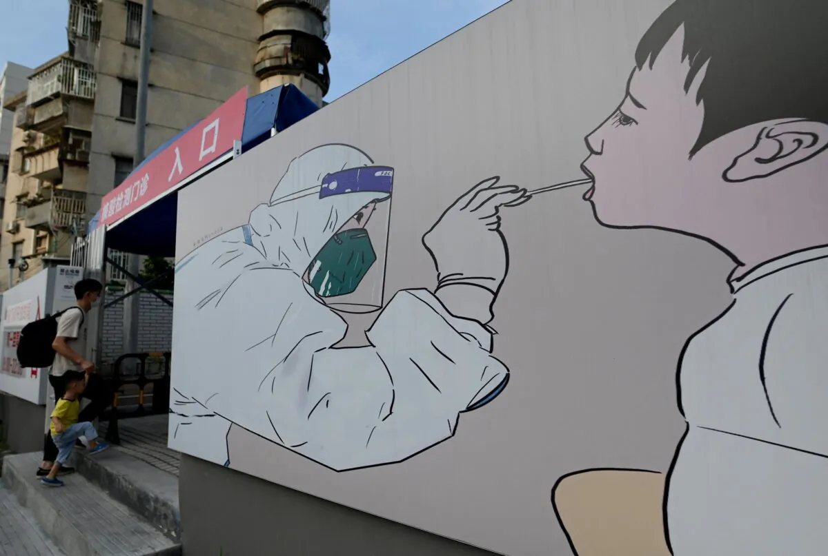 A man and a boy enter a nucleic acid sample collection center for COVID-19 test in Shenzhen, southeastern China on September 26, 2021. (NOEL CELIS/AFP via Getty Images)