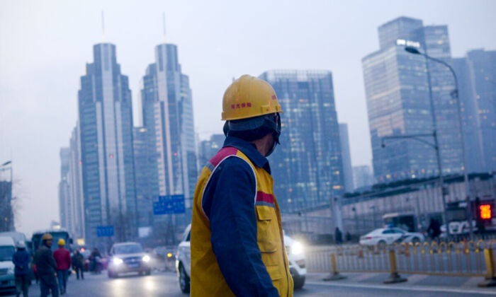 A Chinese worker looks back as he walks along a street after work in Beijing on Dec. 28, 2015. (Wang Zhao/AFP via Getty Images)