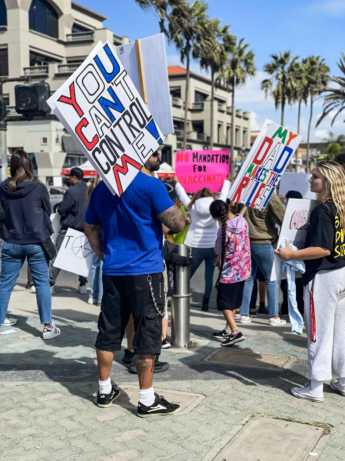 Hundreds of parents, teachers, and students rallied nearby the Huntington Beach pier as part of the state-wide "walk-out" to denounce California’s COVID-19 vaccine mandate for K-12 students in Huntington Beach, Calif., on Oct. 18, 2021. (Vanessa Serna/The Epoch Times)

