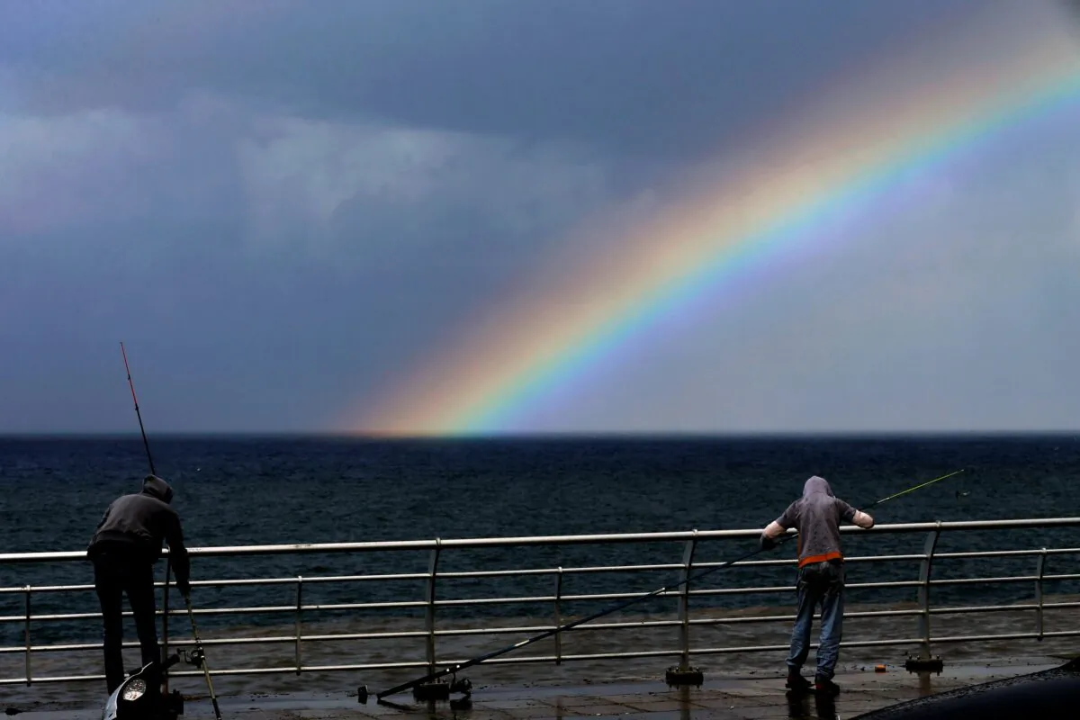 Fishermen prepare to fish as a rainbow appears over the Mediterranean Sea in Beirut, Lebanon, on Oct. 17, 2021. (Bilal Hussein/AP Photo)
