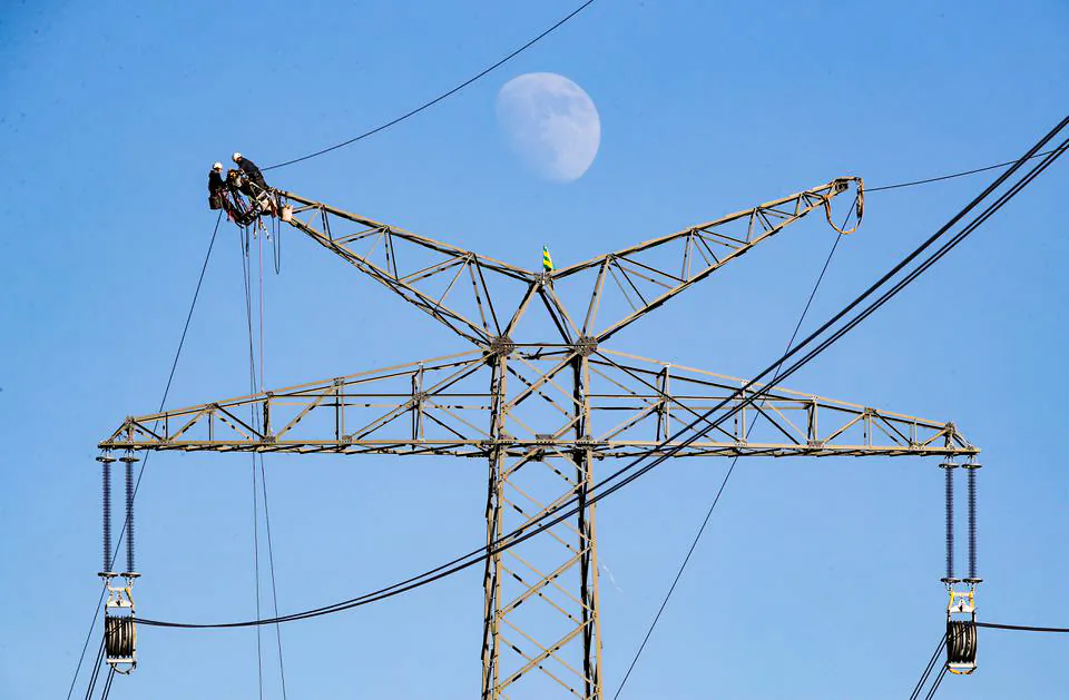 Electricians work atop a power pole near the lignite power plant in Neurath of German energy supplier and utility RWE, Germany. (Wolfgang Rattay/Reuters)