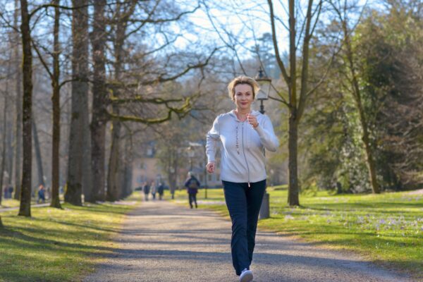 woman speed walking through a park