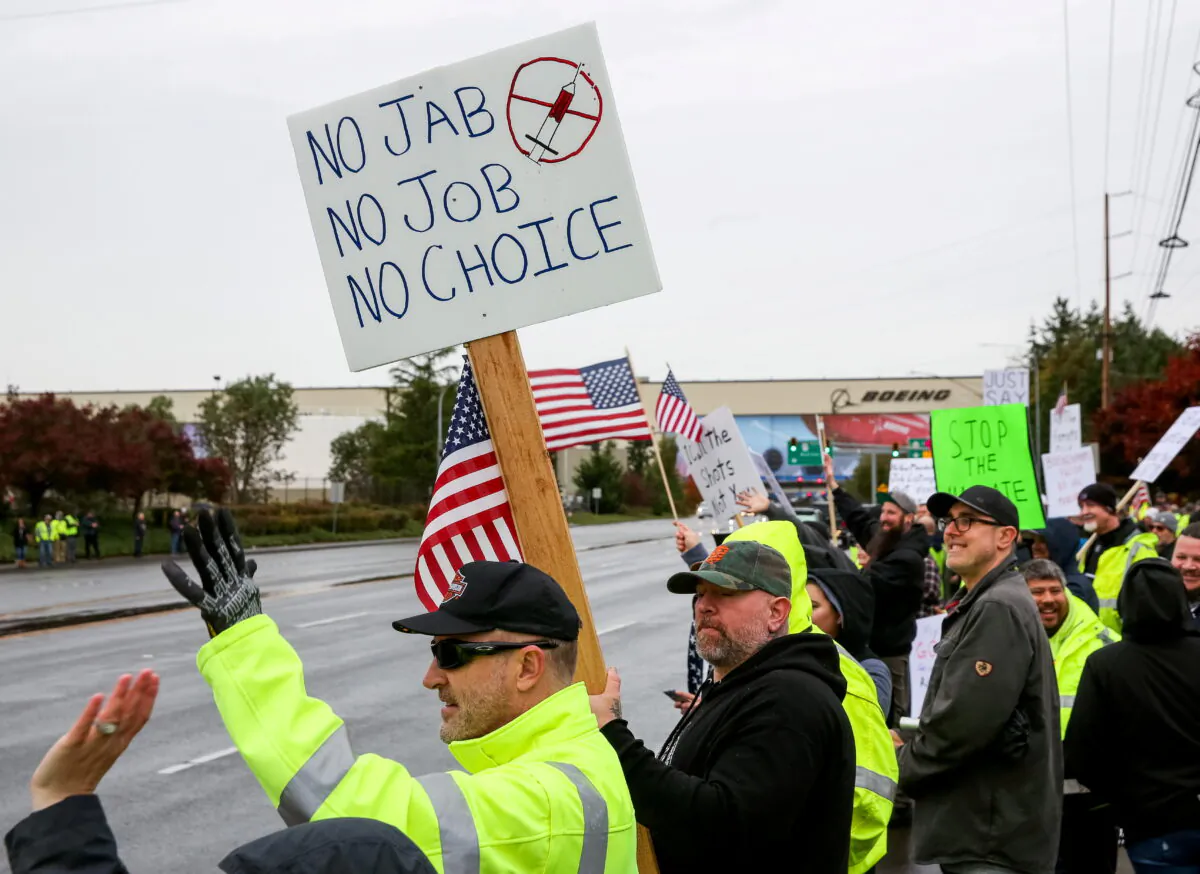 Boeing employees and others line the street with signs and American flags as they protest the company's COVID-19 vaccine mandate, outside the Boeing facility in Everett, Washington, on Oct. 15, 2021. (Lindsey Wasson/Reuters)