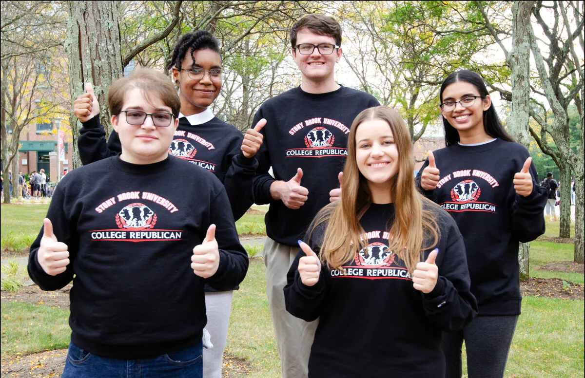 Members of the Stony Brook University College Republicans—Gabriel Vieira (L), Thalyann Olivo (2nd L), Kenny Rothwell (3rd R), Sara Adcock (2nd R) and Anushka Bhatt (R)—give the President Trump-style "thumbs up" on the campus in Stony Brook, New York, on Oct. 13, 2021. (Dave Paone/Epoch Times)