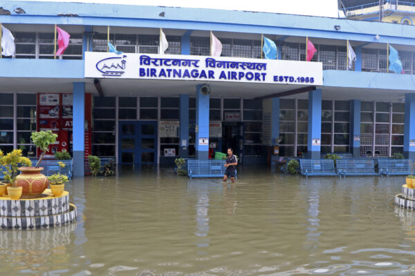 A man wades through the flooded entrance of a domestic airport after heavy rains in Biratnagar, Nepal, on Oct. 20, 2021. (Lila Ballav Ghimire/AFP via Getty Images)