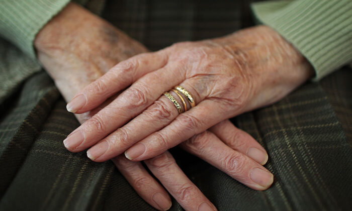 An elderly woman sits at home with her hands on her lap in Surrey, England, on Feb. 17, 2010. (Peter Macdiarmid/Getty Images)