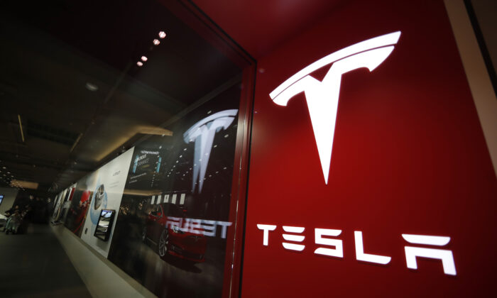 A sign bearing the company logo stands outside a Tesla store in Cherry Creek Mall in Denver, Colo., on Feb. 9, 2019. (David Zalubowski/AP Photo)