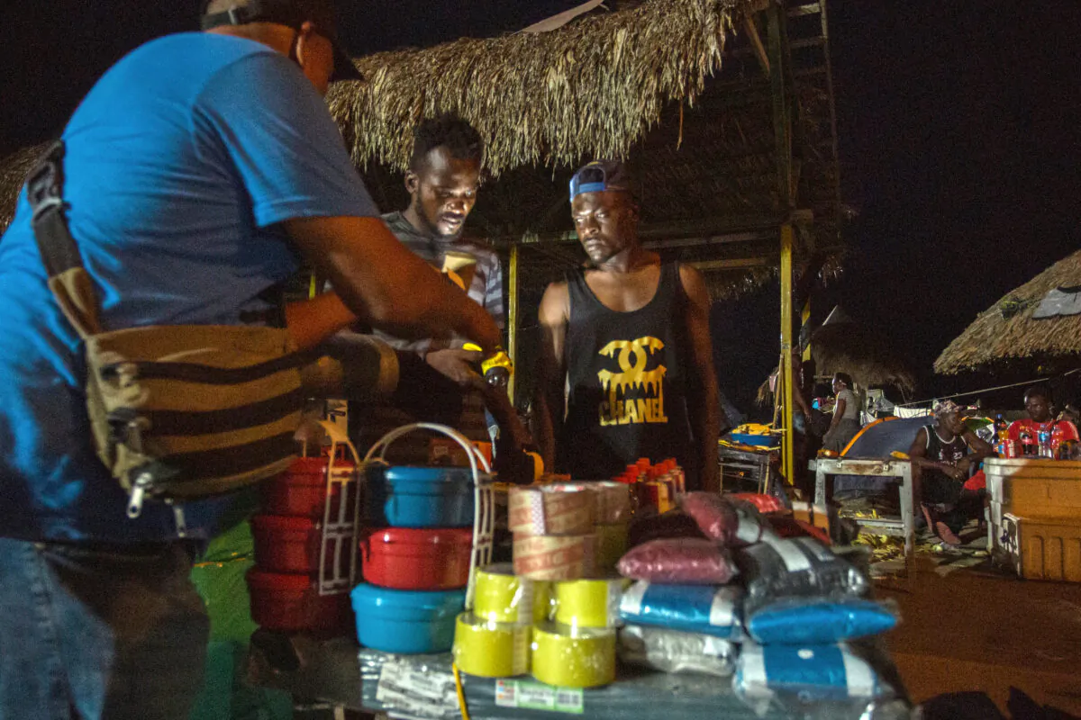 Haitians buy supplies at an open market in Necocli, Colombia, on Oct. 12, 2021. (Alejandro Gomez for The Epoch Times)