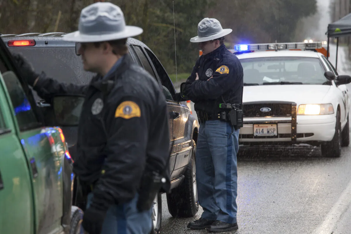Washington State Patrol troopers stop vehicles at a road block on Washington Highway 530 near a massive mudslide in Darrington, Wash., on March 28, 2014. (David Ryder/Getty Images)