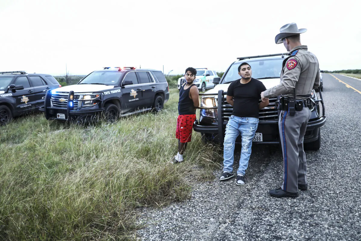 Texas State Troopers arrest two U.S. citizens who were transporting three illegal aliens to San Antonio, in Kinney County, Texas, on Oct. 20, 2021. (Charlotte Cuthbertson/The Epoch Times)