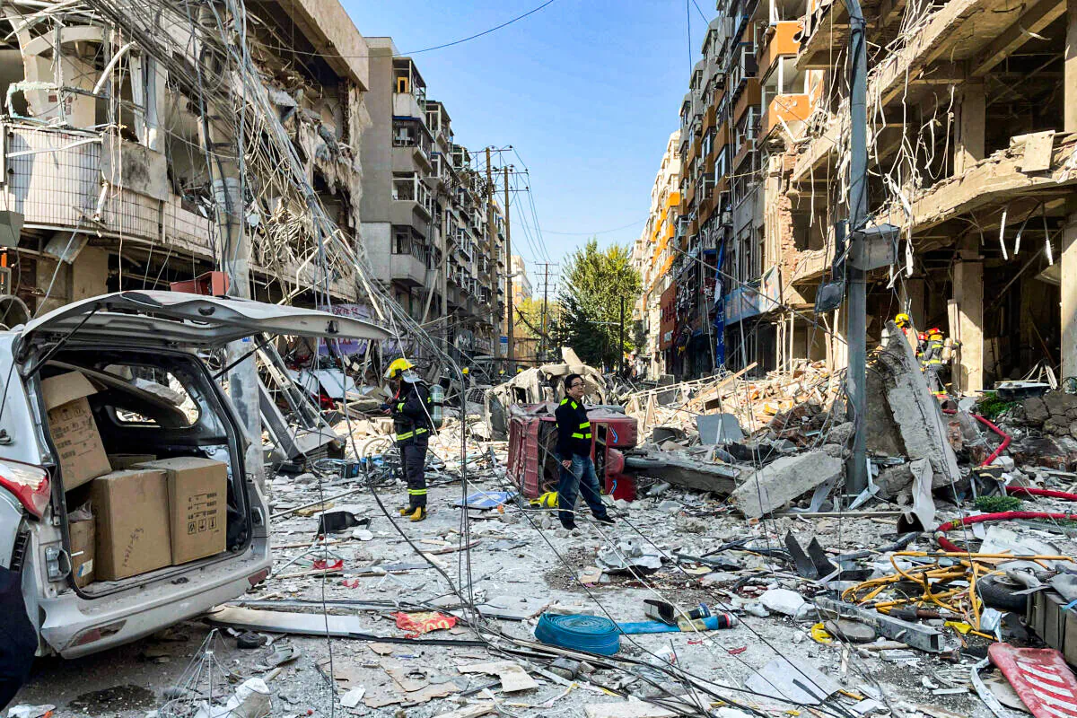In this photo released by Xinhua News Agency, policemen and firefighters walk through damaged shophouses following a gas explosion in Shenyang in northeastern China's Liaoning Province, Thursday, Oct. 21, 2021. Several people were killed and over dozen injured in the gas explosion at a restaurant in northeastern Chinese city Shenyang Thursday morning, according to local authorities. (Cai Xiangxin/Xinhua via AP)