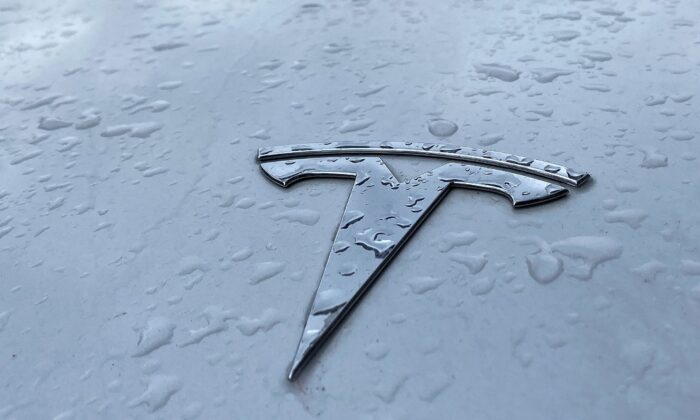 Raindrops are seen next to the Tesla logo on the bonnet of a Tesla electric car in Berlin's Kreuzberg district on March 15, 2021. (David Gannon/AFP via Getty Images)