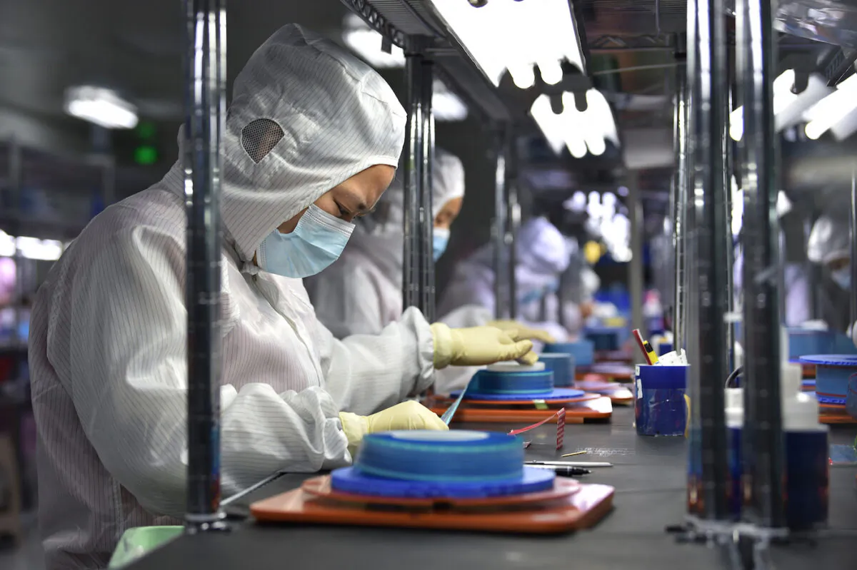 Workers produce adhesive tapes for flexible printed circuits at a factory in Yancheng, Jiangsu Province, China, on Sept. 15, 2021. (STR/AFP via Getty Images)