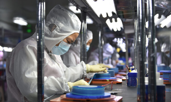 Workers produce adhesive tapes for flexible printed circuits at a factory in Yancheng in China's eastern Jiangsu Province on Sept.15, 2021. (STR/AFP via Getty Images)