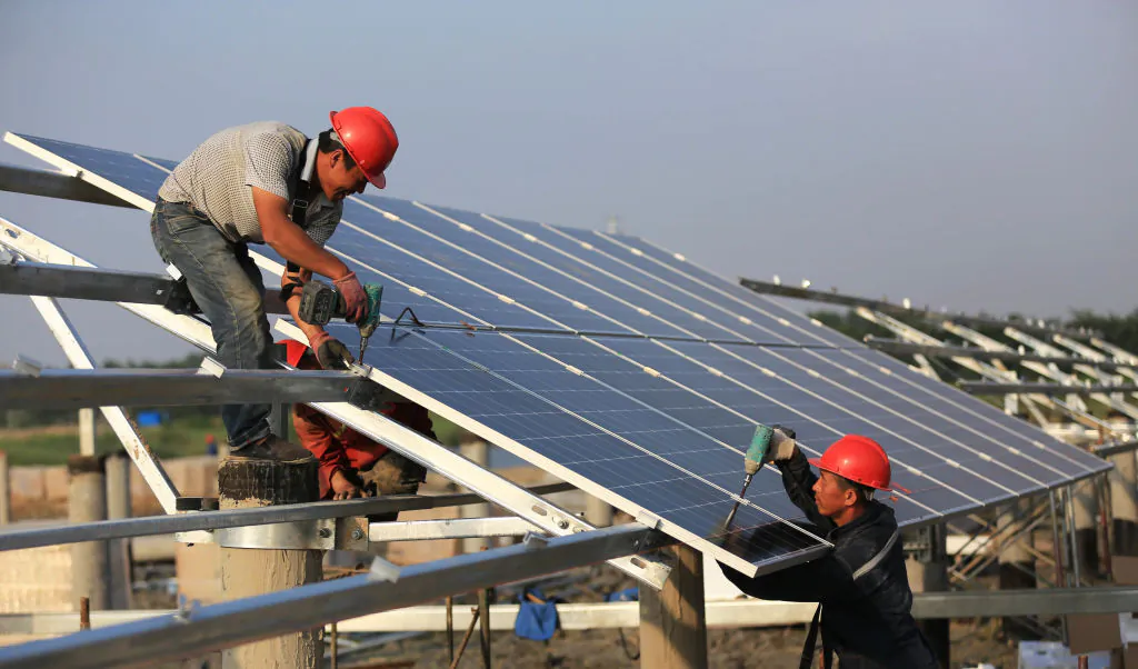 Workers install solar panels at the construction site of 40MW photovoltaic on-grid power project in Huai an, China, on June 11, 2018. (VCG/VCG via Getty Images)