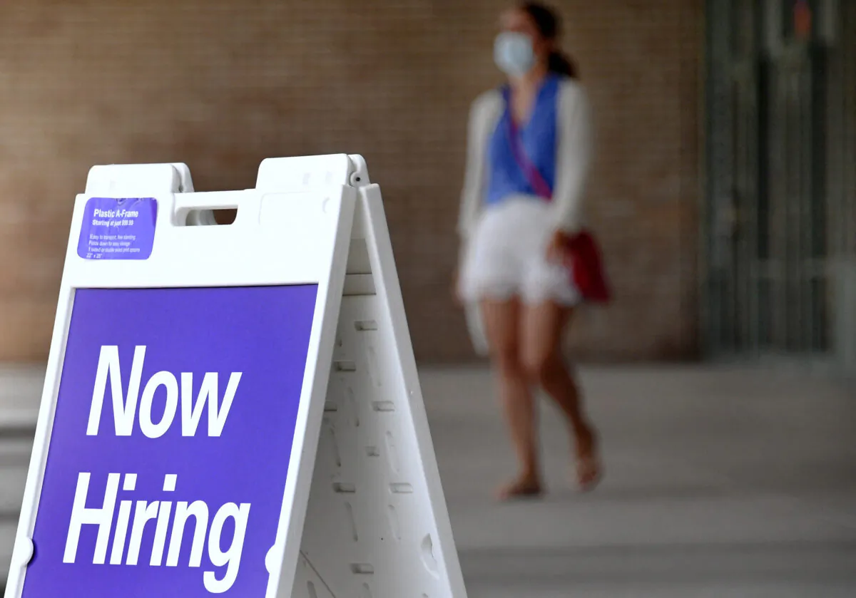 Pedestrians walk by a "Now Hiring" sign outside a store in Arlington, Va., on Aug. 16, 2021. (Olivier Douliery/AFP via Getty Images)