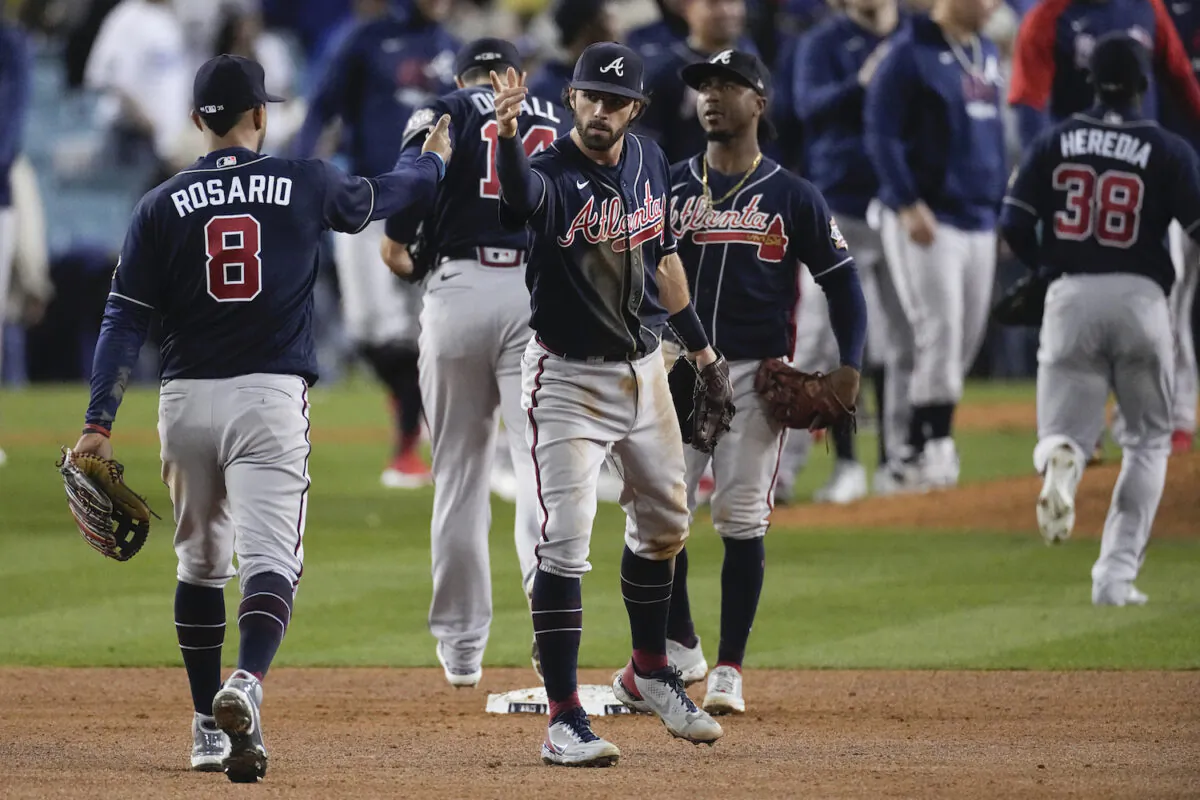 Atlanta Braves left fielder Eddie Rosario (8) is congratulated by teammates after Game 4 of baseball’s National League Championship Series in Los Angeles on Oct. 20, 2021. The Braves defeated the Dodgers 9-2 and lead the series 3-1 games. (AP Photo/Marcio Jose Sanchez)