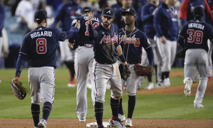 Atlanta Braves left fielder Eddie Rosario (8) is congratulated by teammates after Game 4 of baseball’s National League Championship Series in Los Angeles on Oct. 20, 2021.  Braves defeated the Dodgers 9-2 and lead the series 3-1 games. (AP Photo/Marcio Jose Sanchez)