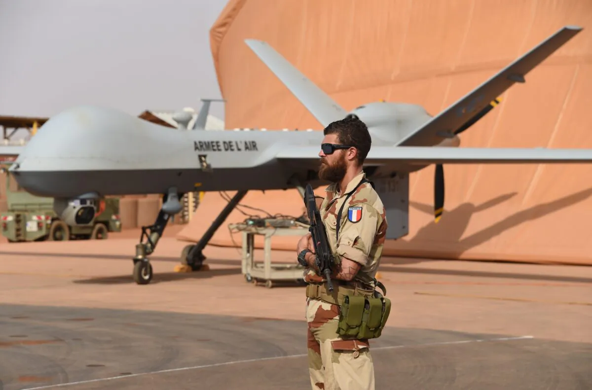 A French soldier involved in the regional anti-insurgent Operation Barkhane stands guard next to a Reaper drone at the French military airbase in Niamey on March 14, 2016. (Pascal Guyot/AFP via Getty Images)