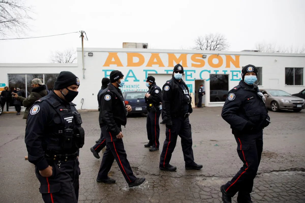 Police gather in the parking lot of Adamson Barbecue, an Etobicoke business that has defied provincial shutdown orders, on Nov. 25, 2020 in Toronto, Canada. (Cole Burston/AFP via Getty Images)
