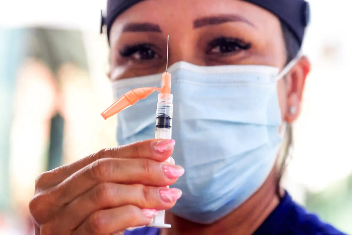 Vocational nurse Christina Garibay displays a syringe with Johnson & Johnson's Janssen Covid-19 vaccine at a Skid Row community outreach event where Covid-19 vaccines and testing were offered in Los Angeles, California on August 22, 2021. (Photo by Frederic J. BROWN / AFP) (Photo by FREDERIC J. BROWN/AFP via Getty Images)