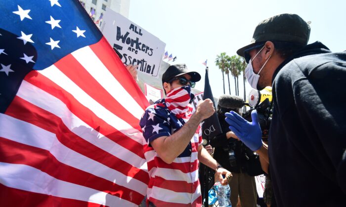 A protester (L) argues with a counter-protester (R) in front of the Los Angeles City Hall on May 1, 2020. (Frederic J. Brown/AFP via Getty Images)