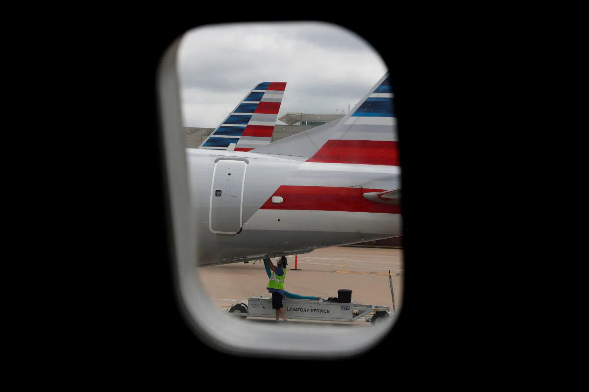 An airlines worker works on an American Airlines plane that arrived at Hartsfield–Jackson Atlanta International Airport in Atlanta, Ga. on May 19, 2020. (Shannon Stapleton/Reuters)