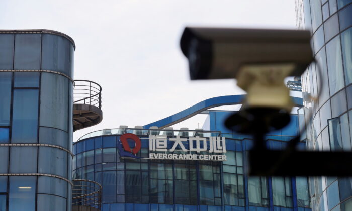 A surveillance camera is seen near the logo of the China Evergrande Group at the Evergrande Center in Shanghai, China, on September 24, 2021. (Aly Song/Reuters)