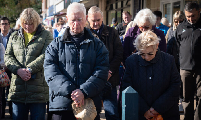 Shopkeepers and local residents gather to observe a two-minute silence in memory of MP Sir David Amess in Eastwood Road North, Leigh-on-Sea, Essex, England, on Oct. 22, 2021. (Stefan Rousseau/PA)