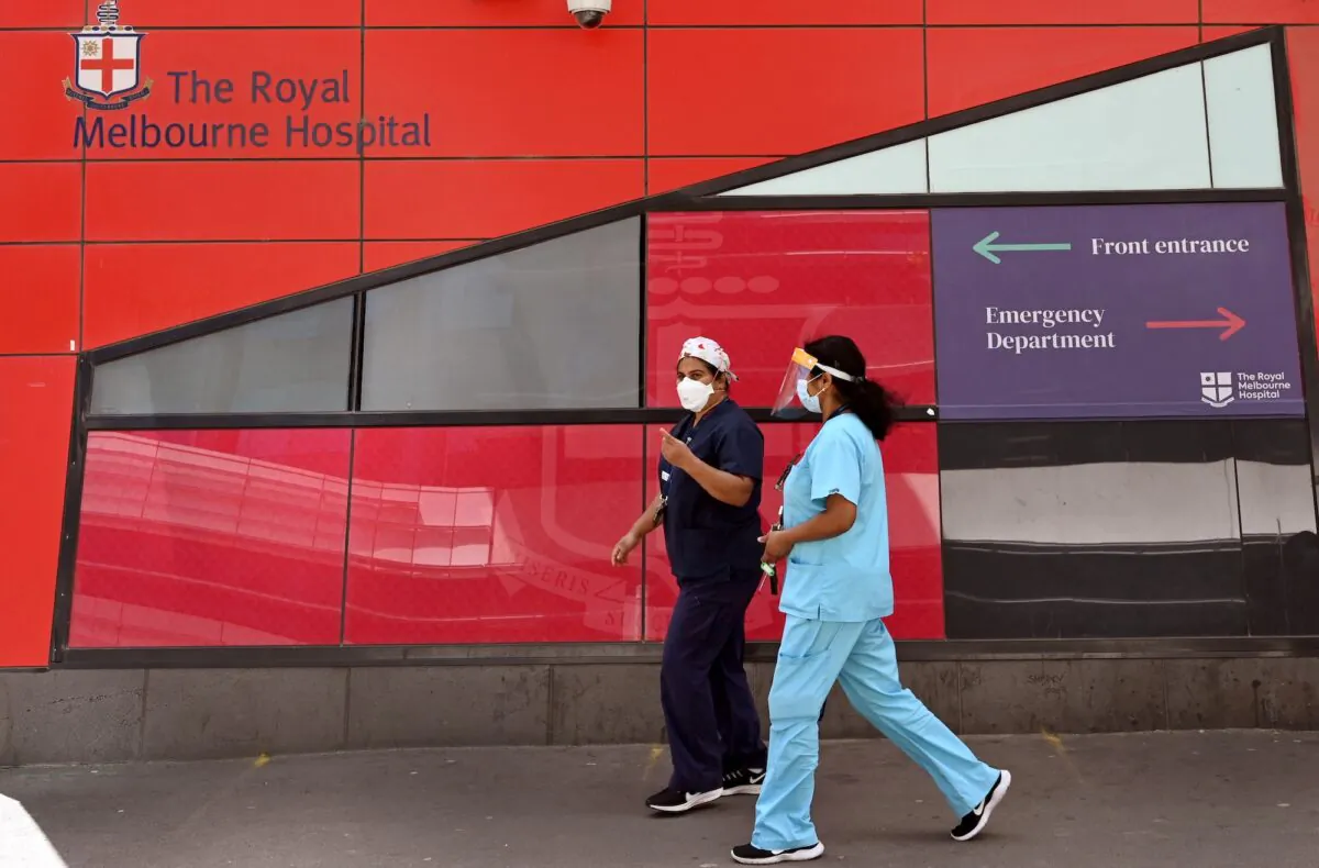 Medical staff walk past the emergency entrance at the Royal Melbourne Hospital in Melbourne, Australia, on Oct. 9, 2021. (William West / AFP via Getty Images)