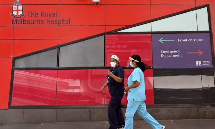 Medical staff walk past the emergency entrance at the Royal Melbourne Hospital in Melbourne, Australia, on Oct. 9, 2021. (William West / AFP via Getty Images)