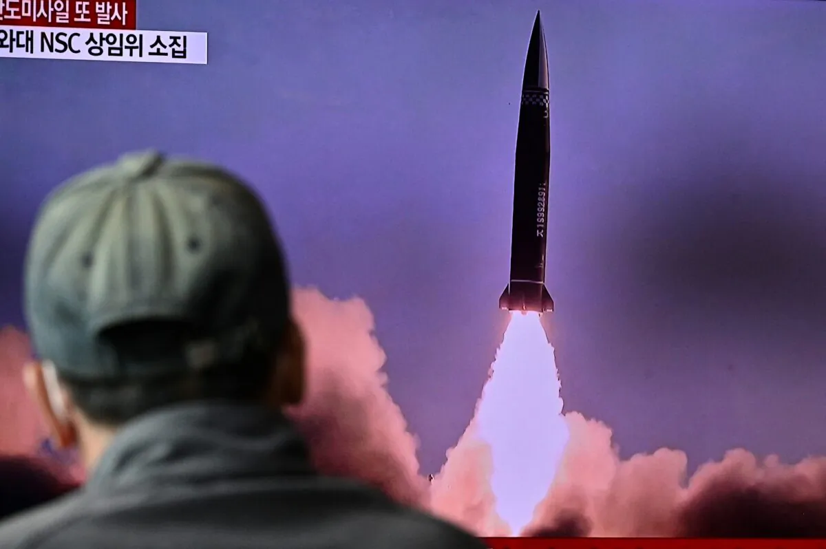 A man watches a television report showing a news broadcast with file footage of a North Korean missile test, at a railway station in Seoul on Oct. 19, 2021. (Anthony Wallace / AFP via Getty Images)