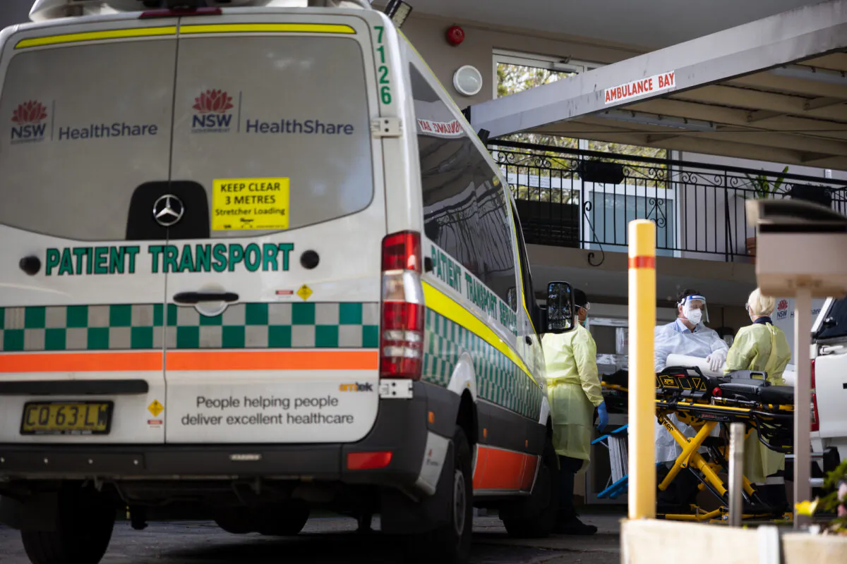 Ambulance attendants wearing full protective clothing prepare a gurney to transport residents to hospital at the Wyoming Nursing Home on August 2, 2021 in Sydney, Australia. The Wyoming Nursing Home in Sydney's inner west, run by Hardi Aged Care, has reported 18 Covid-19 cases in residents and a further two in staff, sending the remainder of the home's top floor residents to hospital as a precaution. Covid-19 lockdown restrictions in hot spot local government areas have increased with masks required outdoors at all times and residents limited to movement within a 5 kilometre radius of their homes. Greater Sydney is in lockdown through August 28th to contain the highly contagious Covid-19 delta variant. (Photo by Sean Foster/Getty Images)