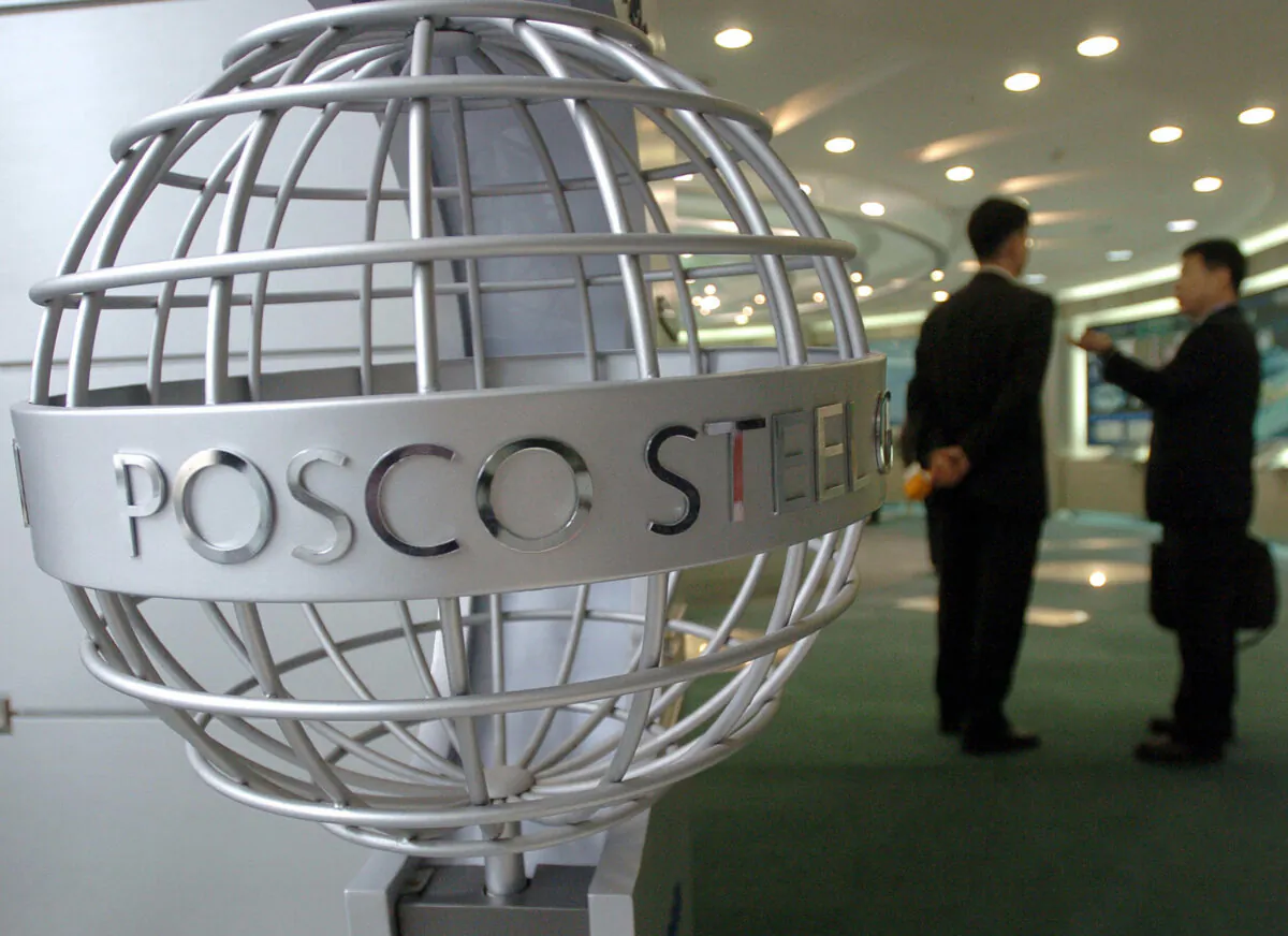 Business men talk at a lobby of the headquarters of POSCO, the world's fifth largest steel maker, in Seoul, on March 9, 2006. (Jung Yeon-je/AFP via Getty Images)