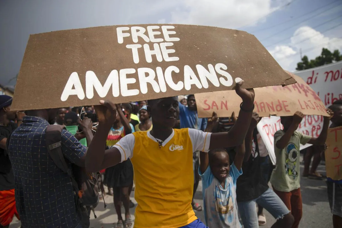 People protest for the release of kidnapped missionaries near the Ohio-based Christian Aid Ministries headquarters in Titanyen, north of Port-au-Prince, Haiti, on Oct. 19, 2021. (Joseph Odelyn/AP Photo)