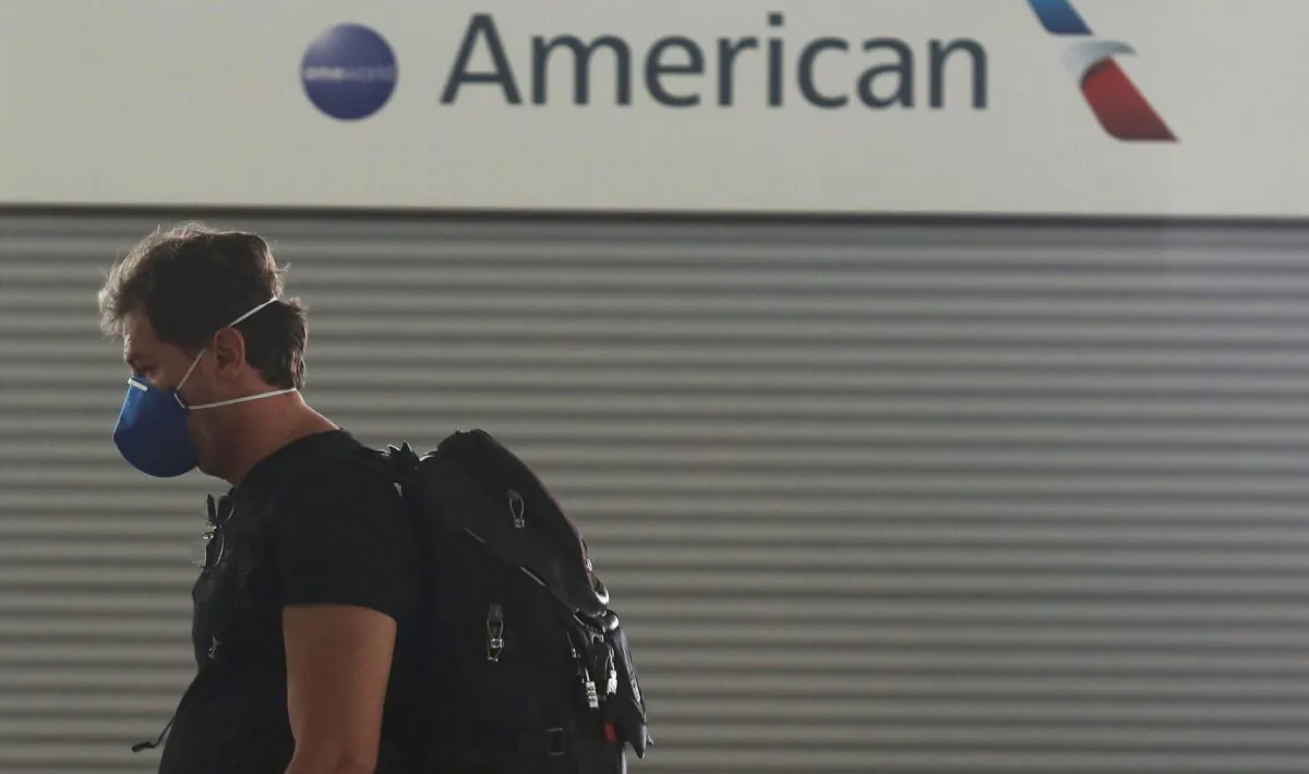 A passenger wears a protective mask as he walks past the American Airlines ticketing desk at Josep Tarradellas Barcelona-El Prat Airport in Barcelona, Spain, on March 12, 2020. (Nacho Doce/Reuters)
