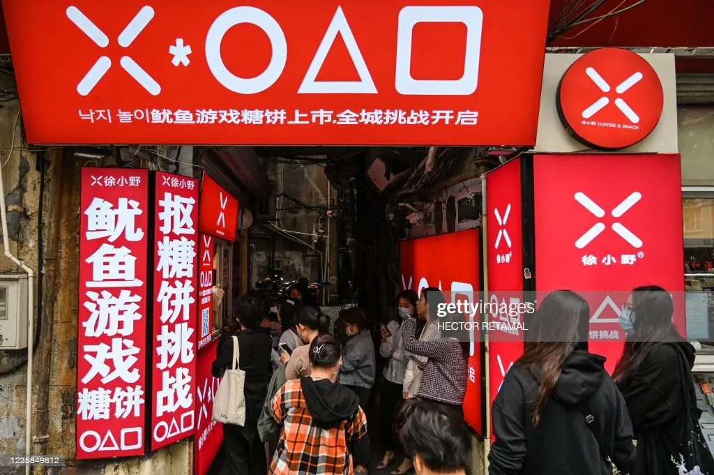 Customers are lining up at a small shop to buy dalgonas, a crisp sugar candy featured in Squid Game, in Shanghai, China, on Oct. 12, 2021. (Hector Retamal/AFP via Getty Images) 