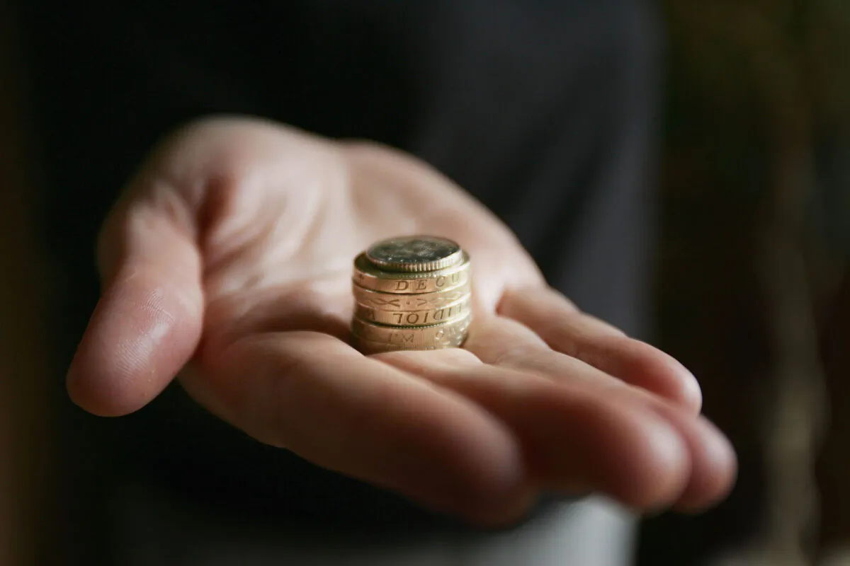 A hand holding coins in Glasgow, Scotland, on March 11, 2005. (Photo illustration by Christopher Furlong/Getty Images)