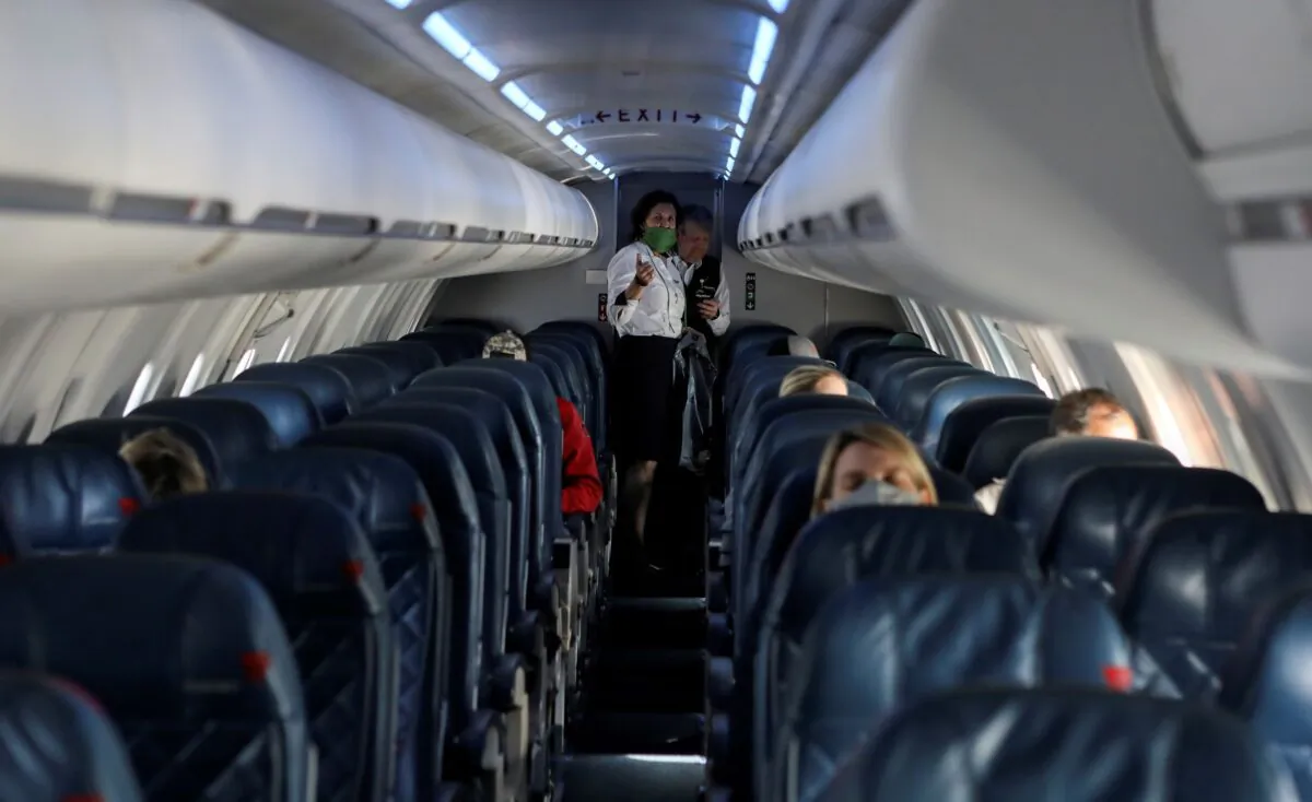 Flight attendants talk in a nearly empty cabin on a Delta Airlines flight operated by SkyWest Airlines as travel has cutback, amid concerns of the coronavirus disease (COVID-19), during a flight departing from Salt Lake City, Utah on April 11, 2020. (Jim Urquhart/Reuters)