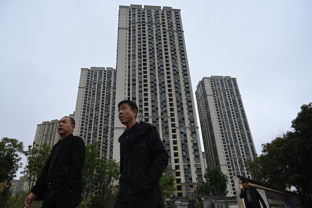 People walk past a housing complex of Chinese property developer Evergrande in Kunming, in southwestern Yunnan Province on Oct. 23, 2021. (Jade Gao/AFP via Getty Images)